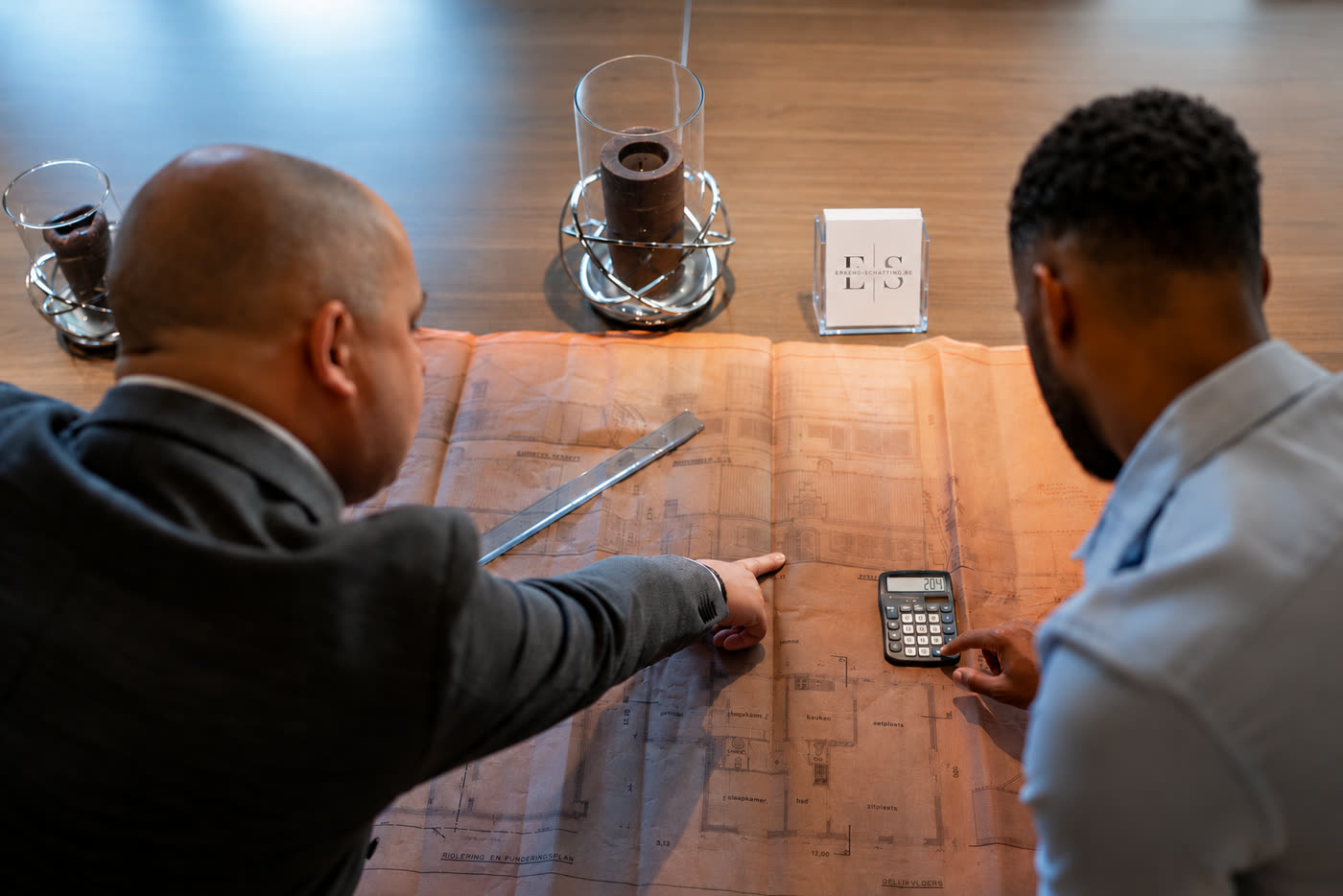 Schatters bekijken samen een bouwplan aan tafel